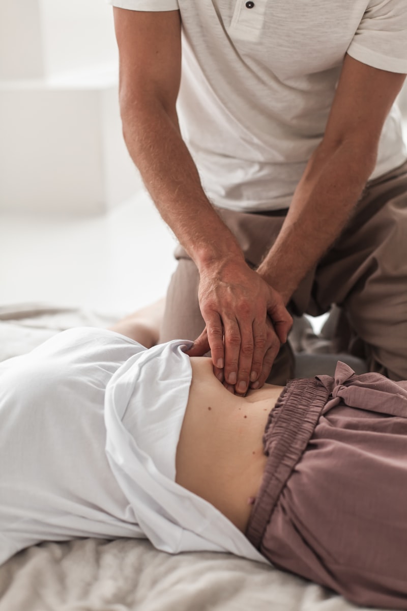 Practitioner gently working on a client's torso during a kinesiology session