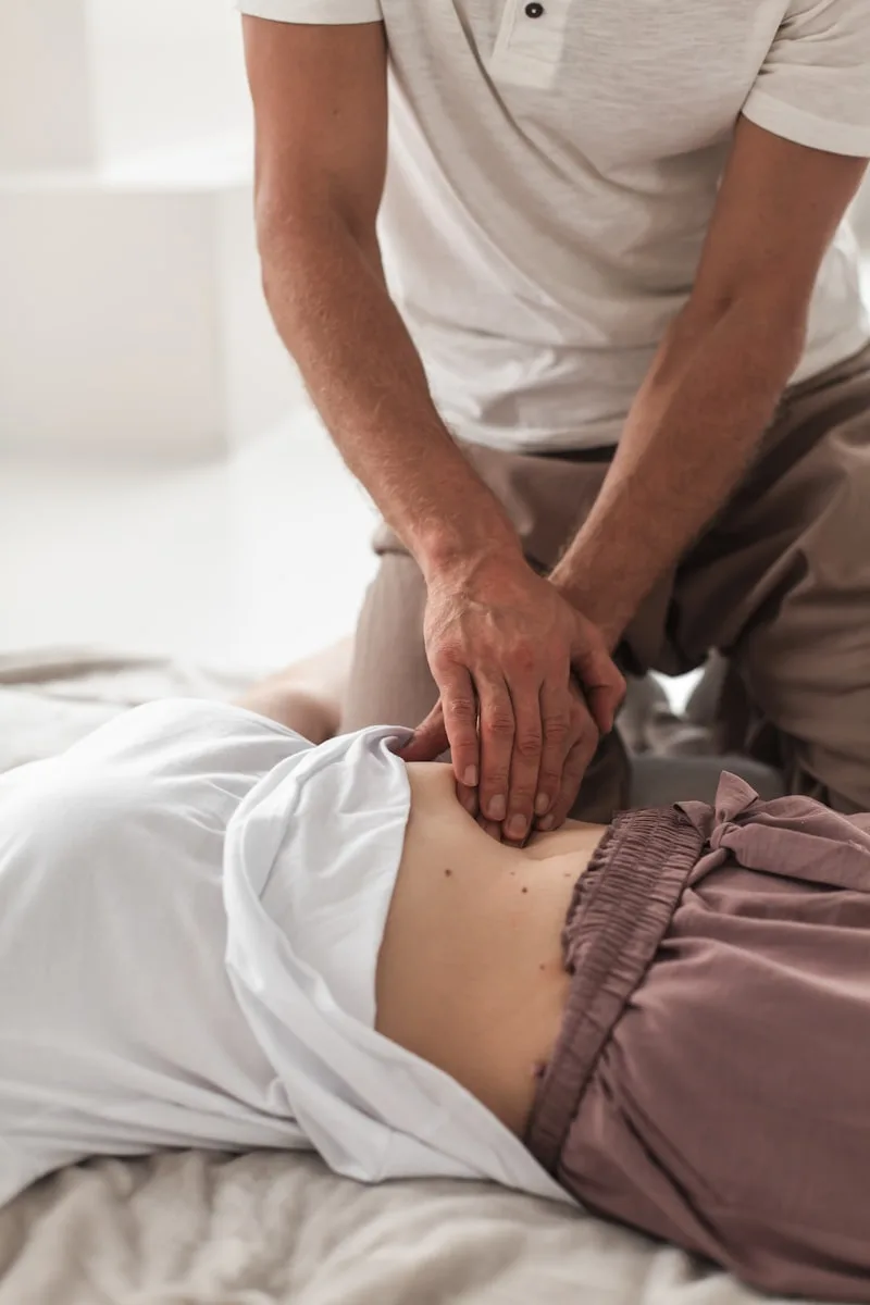 Practitioner gently working on a client's torso during a kinesiology session